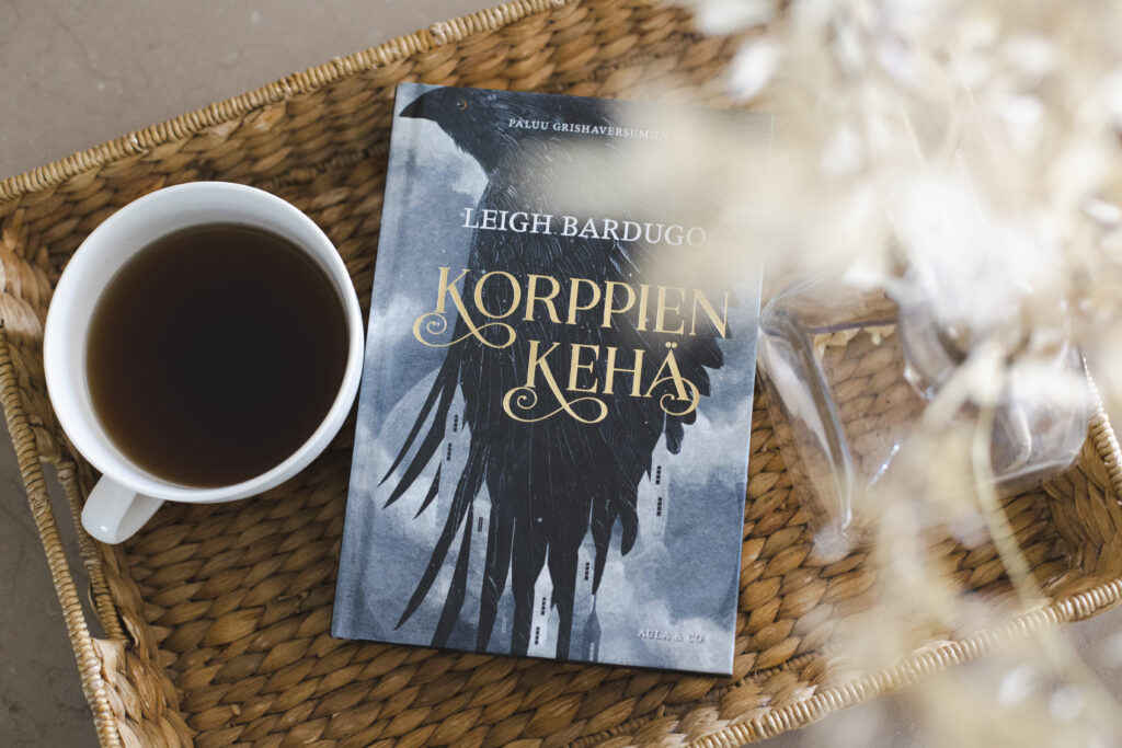 Korppien kehä -kirjan kansi, jonka vieressä kahvikuppi.